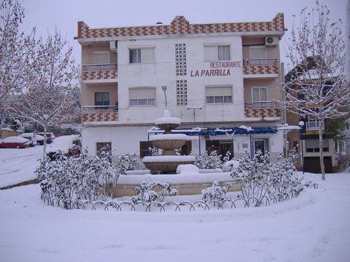Imagen del Restaurante, se puede ver un gran edificio al fondo, en la parte de delante se encentra una fuente cubierta de nieve